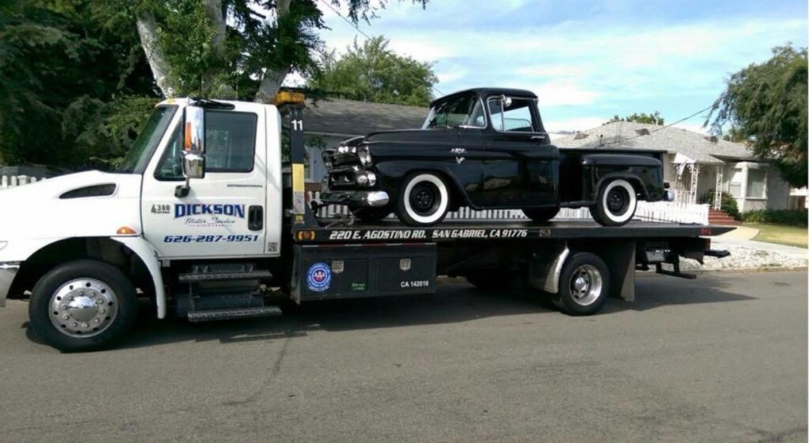 Dickson tow truck transporting a black 1958 Chevy Apache pickup
